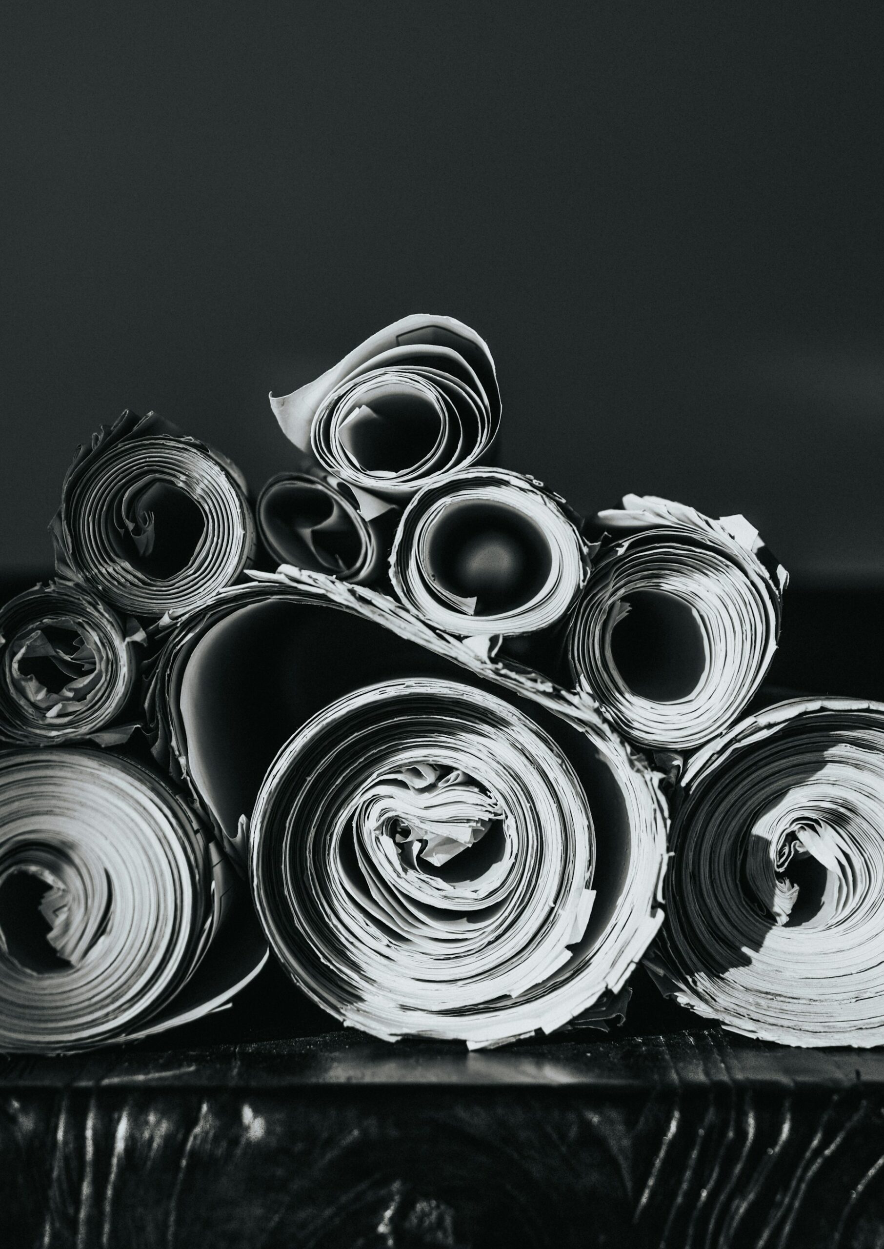 Rolled sheets of paper arranged in a black-and-white composition
